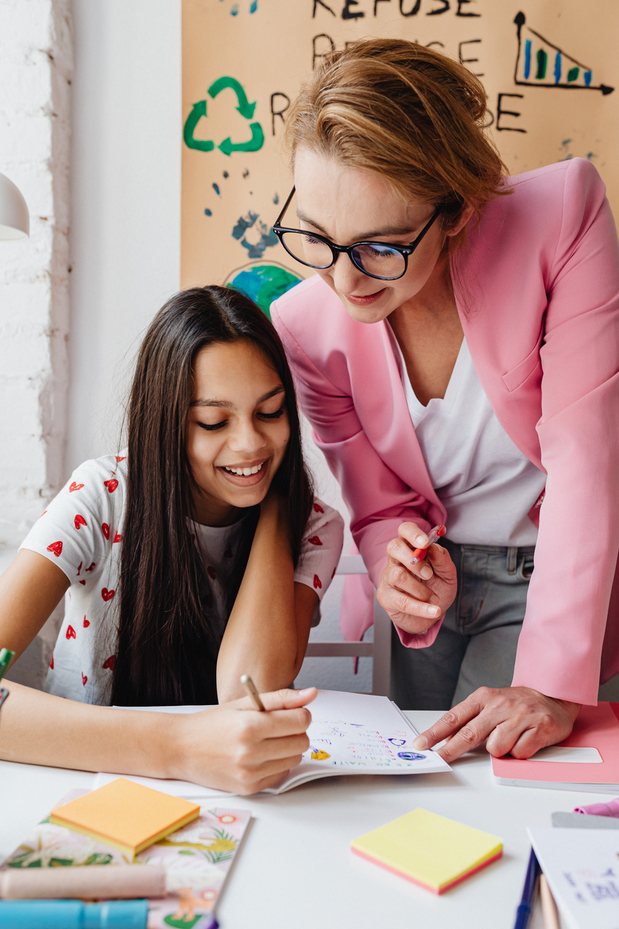 Woman in Pink Blazer Teaching a Girl 